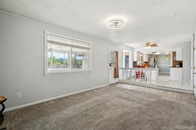 8732 W Arbor Ave, Littleton, CO 80123 - unfurnished living room featuring a textured ceiling, light carpet, and ceiling fan