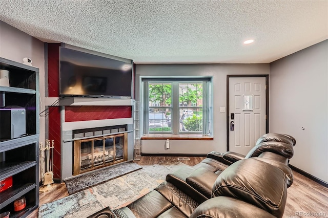 9672 W Chatfield Ave Unit C, Littleton, CO 80128 - living room with a glass covered fireplace, a textured ceiling, wood finished floors, and recessed lighting