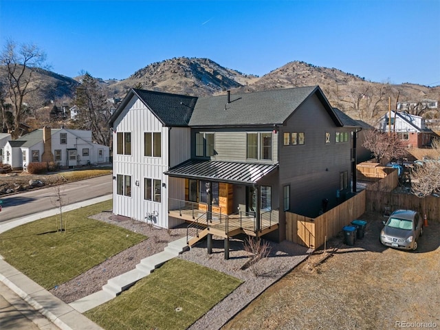 modern farmhouse style home featuring a front yard, a porch, and a mountain view