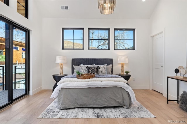 bedroom featuring light hardwood / wood-style floors, multiple windows, and access to exterior