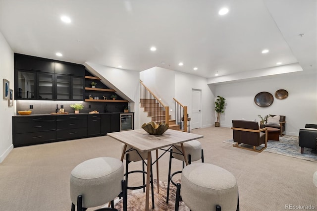 interior space featuring beverage cooler, wet bar, and light carpet