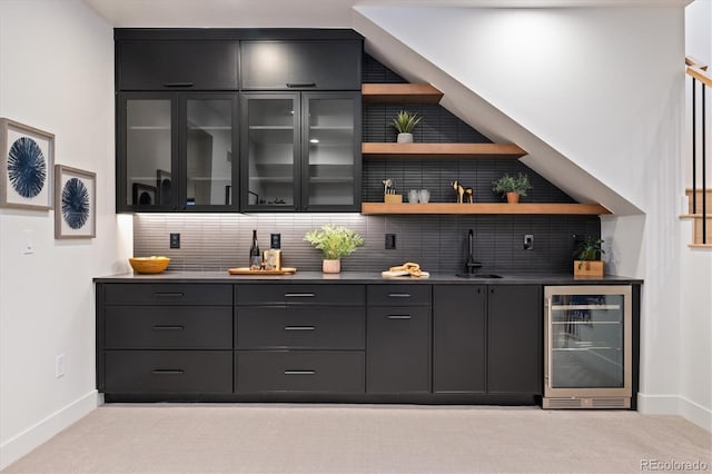 bar featuring sink, beverage cooler, light carpet, and tasteful backsplash