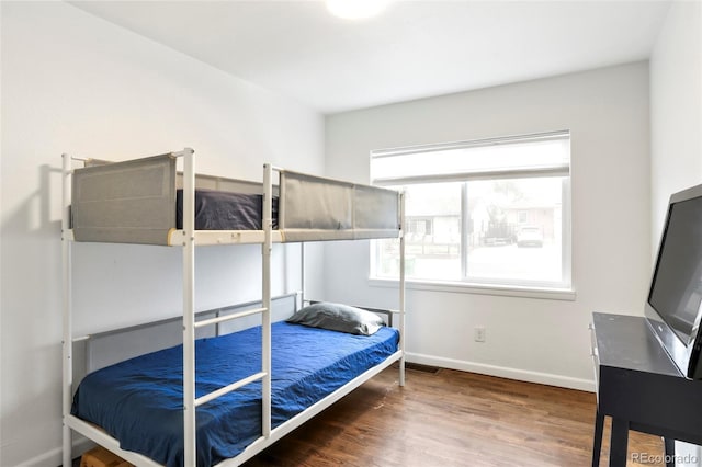 bedroom featuring baseboards and wood finished floors