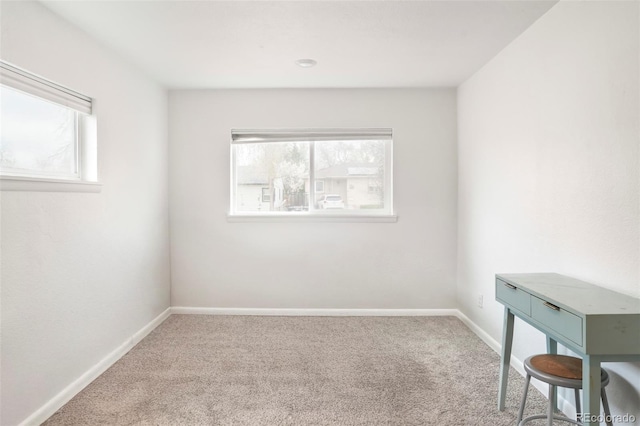 carpeted empty room featuring baseboards