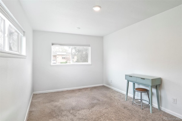spare room with baseboards and carpet