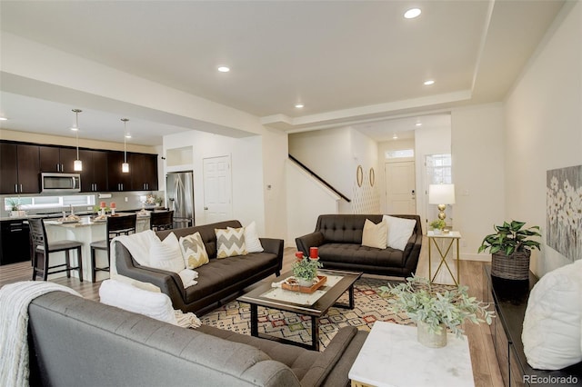 4444 N Picadilly Ct, Aurora, CO 80019 - living room with light wood-type flooring, recessed lighting, stairs, and baseboards