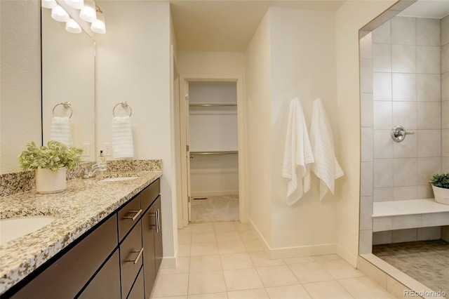 4444 N Picadilly Ct, Aurora, CO 80019 - bathroom with tile patterned flooring, tiled shower, baseboards, double vanity, and a walk in closet