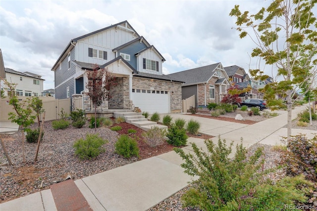 4444 N Picadilly Ct, Aurora, CO 80019 - craftsman house with board and batten siding, driveway, a gate, an attached garage, and stone siding