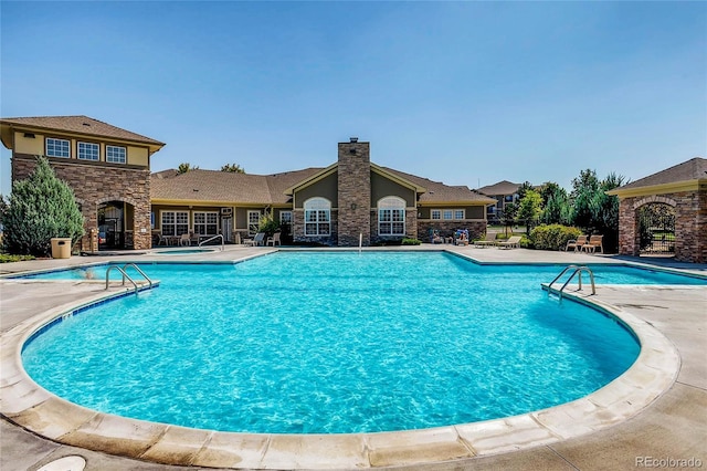 community pool featuring a patio and a community hot tub