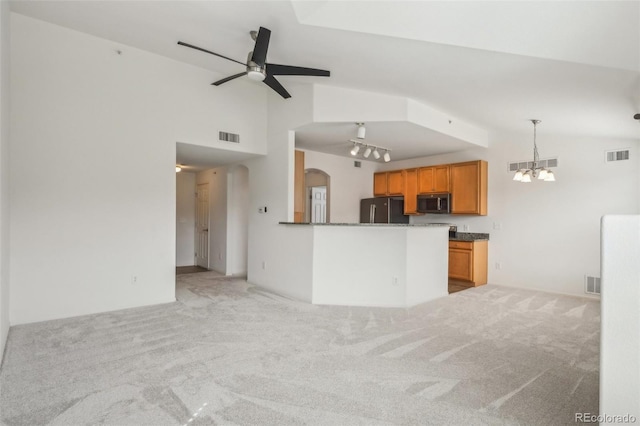 kitchen with stainless steel microwave, visible vents, and freestanding refrigerator