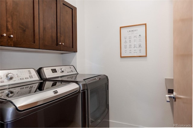 laundry room featuring separate washer and dryer and cabinet space