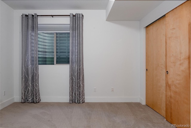 unfurnished bedroom with carpet floors, a closet, and baseboards