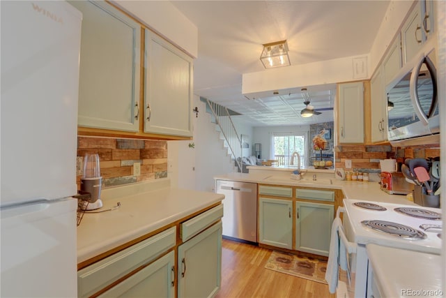 9771 W Cornell Pl, Lakewood, CO 80227 - kitchen with appliances with stainless steel finishes, a sink, light countertops, a ceiling fan, and backsplash