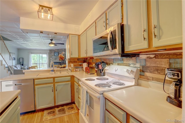 9771 W Cornell Pl, Lakewood, CO 80227 - kitchen featuring appliances with stainless steel finishes, a sink, light countertops, light wood-style flooring, and a ceiling fan