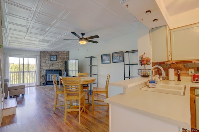 9771 W Cornell Pl, Lakewood, CO 80227 - dining space with a ceiling fan, a stone fireplace, wood finished floors, and an ornate ceiling