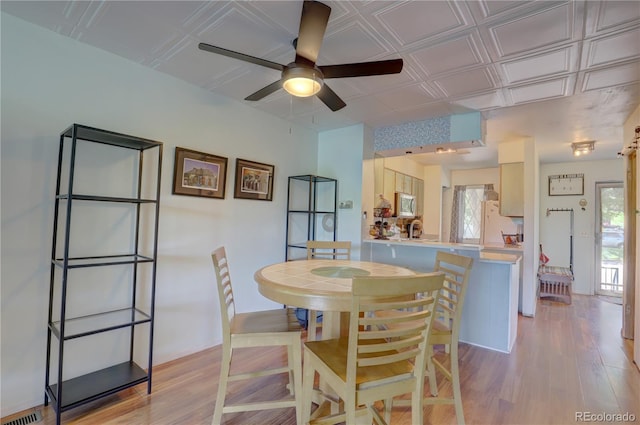 9771 W Cornell Pl, Lakewood, CO 80227 - dining room with light wood-style floors, a ceiling fan, and an ornate ceiling