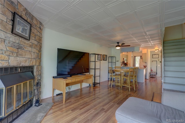 9771 W Cornell Pl, Lakewood, CO 80227 - living area featuring stairs, wood finished floors, a fireplace, and a ceiling fan