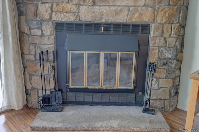 9771 W Cornell Pl, Lakewood, CO 80227 - detailed view of wood finished floors, a wood stove, and baseboards
