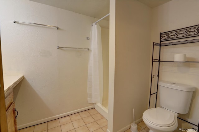 9771 W Cornell Pl, Lakewood, CO 80227 - bathroom featuring toilet, curtained shower, tile patterned floors, and baseboards