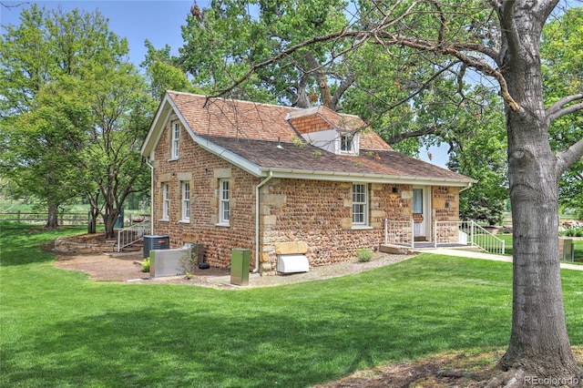 9771 W Cornell Pl, Lakewood, CO 80227 - back of house featuring stone siding, roof with shingles, and cooling unit