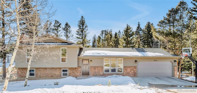 split level home featuring stone siding and an attached garage