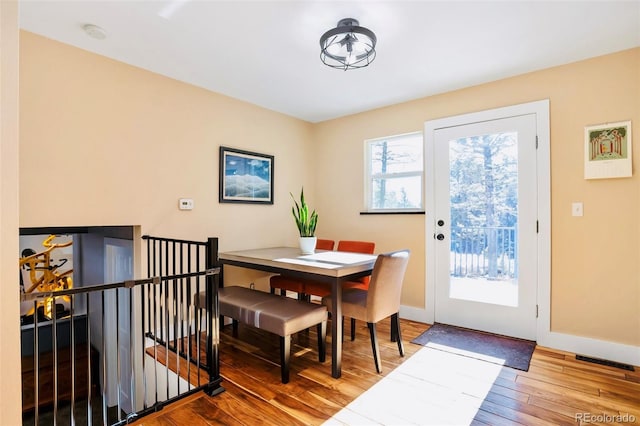 dining area featuring visible vents, wood-type flooring, and baseboards