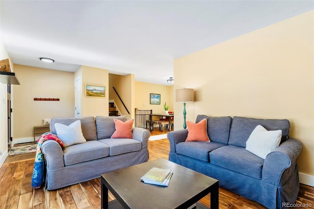 living room featuring stairway, wood finished floors, and baseboards