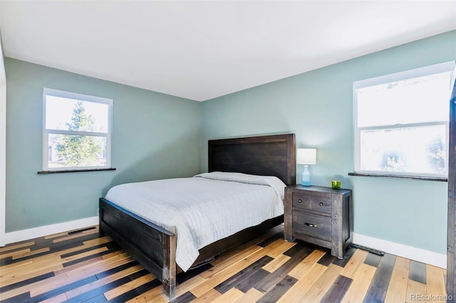 bedroom with baseboards and wood finished floors