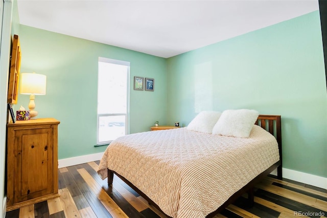 bedroom with hardwood / wood-style floors and baseboards