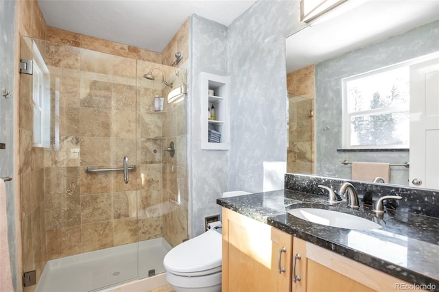 bathroom with vanity, toilet, and a shower stall