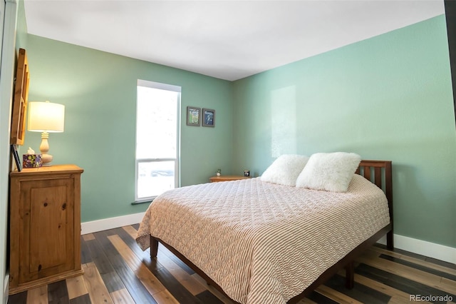 bedroom with baseboards and hardwood / wood-style flooring