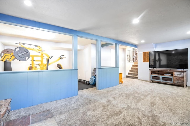 unfurnished living room featuring recessed lighting, carpet flooring, and stairs