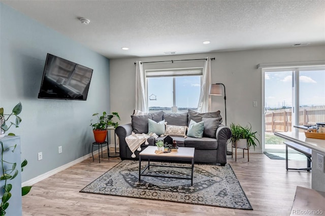 11051 Linley Way, Colorado Springs, CO 80908 - living room with healthy amount of natural light, wood finished floors, a textured ceiling, and recessed lighting