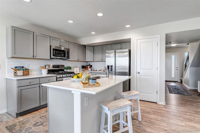 11051 Linley Way, Colorado Springs, CO 80908 - kitchen with stainless steel appliances, gray cabinetry, a sink, a kitchen bar, and recessed lighting