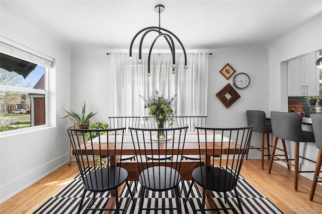 dining space with light wood finished floors and baseboards