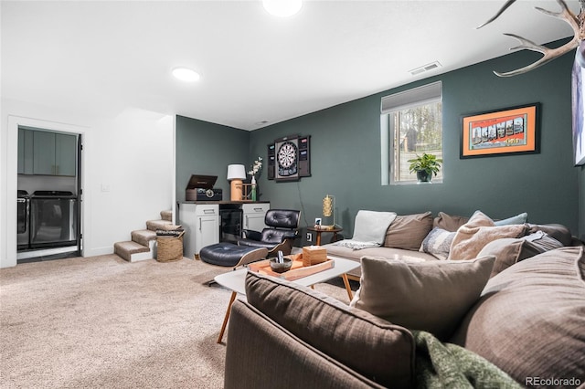 living room featuring washing machine and clothes dryer, carpet flooring, and visible vents
