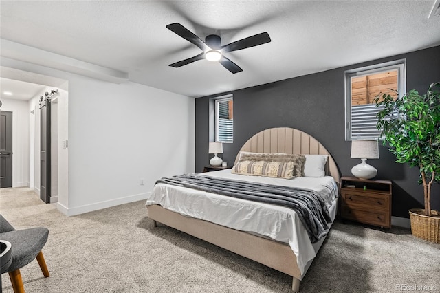 carpeted bedroom with a textured ceiling, baseboards, a ceiling fan, and visible vents