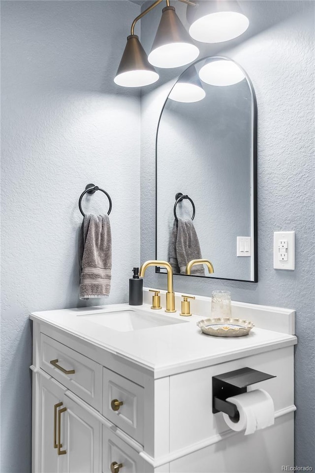 bathroom featuring vanity and a textured wall