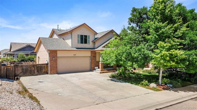 view of front facade with fence, a shingled roof, concrete driveway, a garage, and brick siding