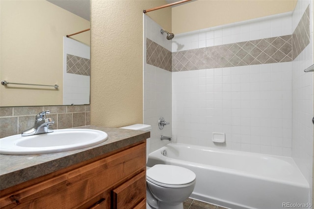 full bathroom with bathtub / shower combination, a textured wall, vanity, and toilet