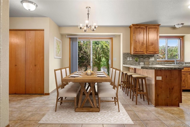 dining room with light tile patterned floors, baseboards, and a notable chandelier