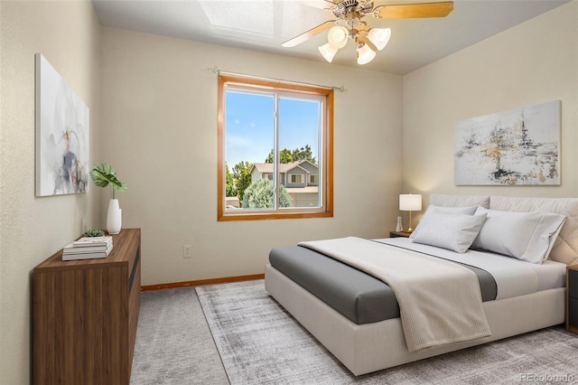 bedroom with light carpet, baseboards, and a ceiling fan