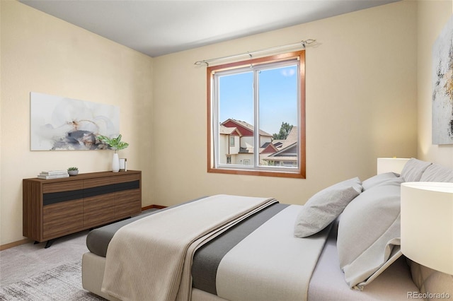 bedroom with light colored carpet and baseboards