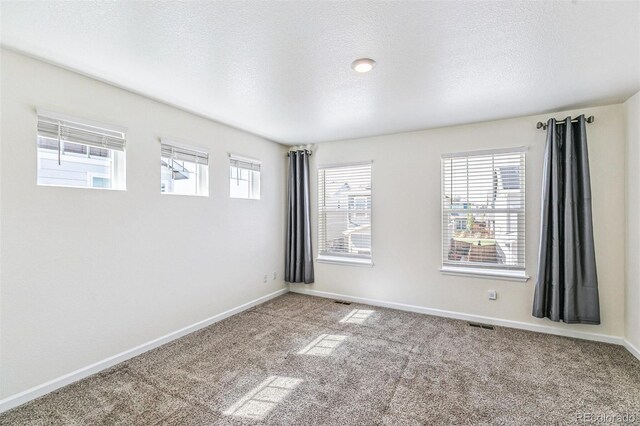 21761 E 7th Ave, Aurora, CO 80018 - empty room featuring carpet flooring, a textured ceiling, and baseboards