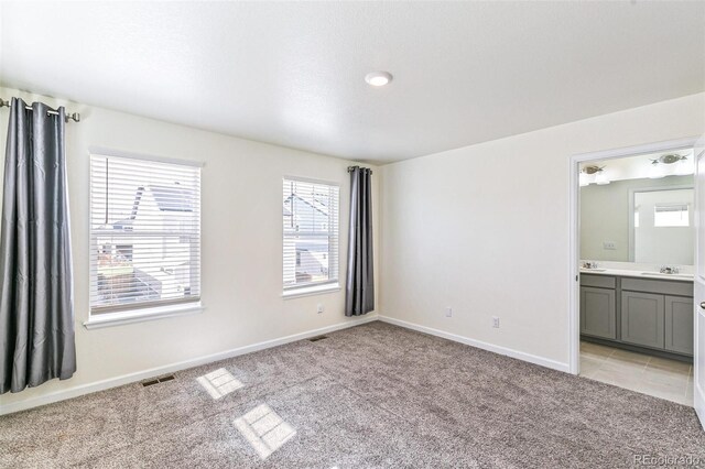 21761 E 7th Ave, Aurora, CO 80018 - unfurnished bedroom featuring light carpet, baseboards, and a sink