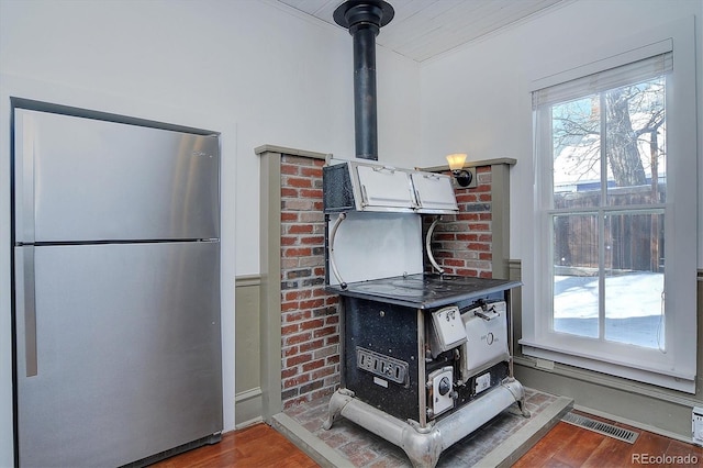 129 Lang St, Twin Lakes, CO 81251 - detailed view of freestanding refrigerator, wood finished floors, a wood stove, and white cabinetry