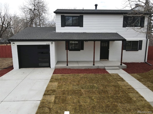 view of front of house featuring a front lawn, a porch, and a garage