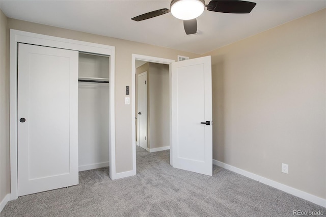 unfurnished bedroom featuring ceiling fan, light colored carpet, and a closet