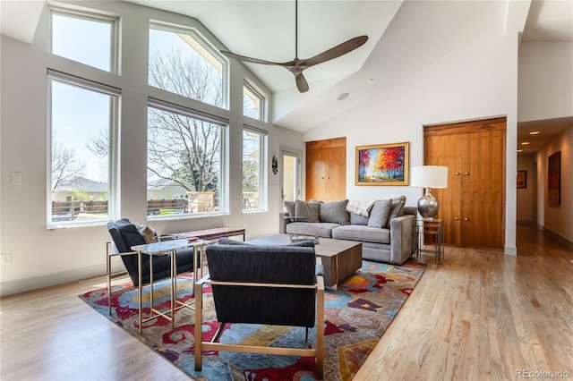 living room featuring high vaulted ceiling, ceiling fan, wood finished floors, and plenty of natural light