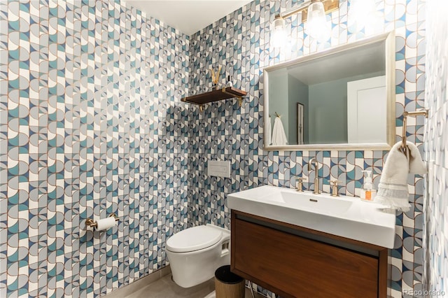 bathroom with tile walls, toilet, and vanity